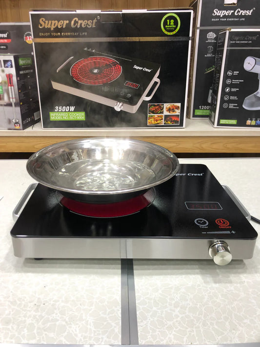 Portable electric stove with a pot on top, displayed in front of Super Crest branded packaging.