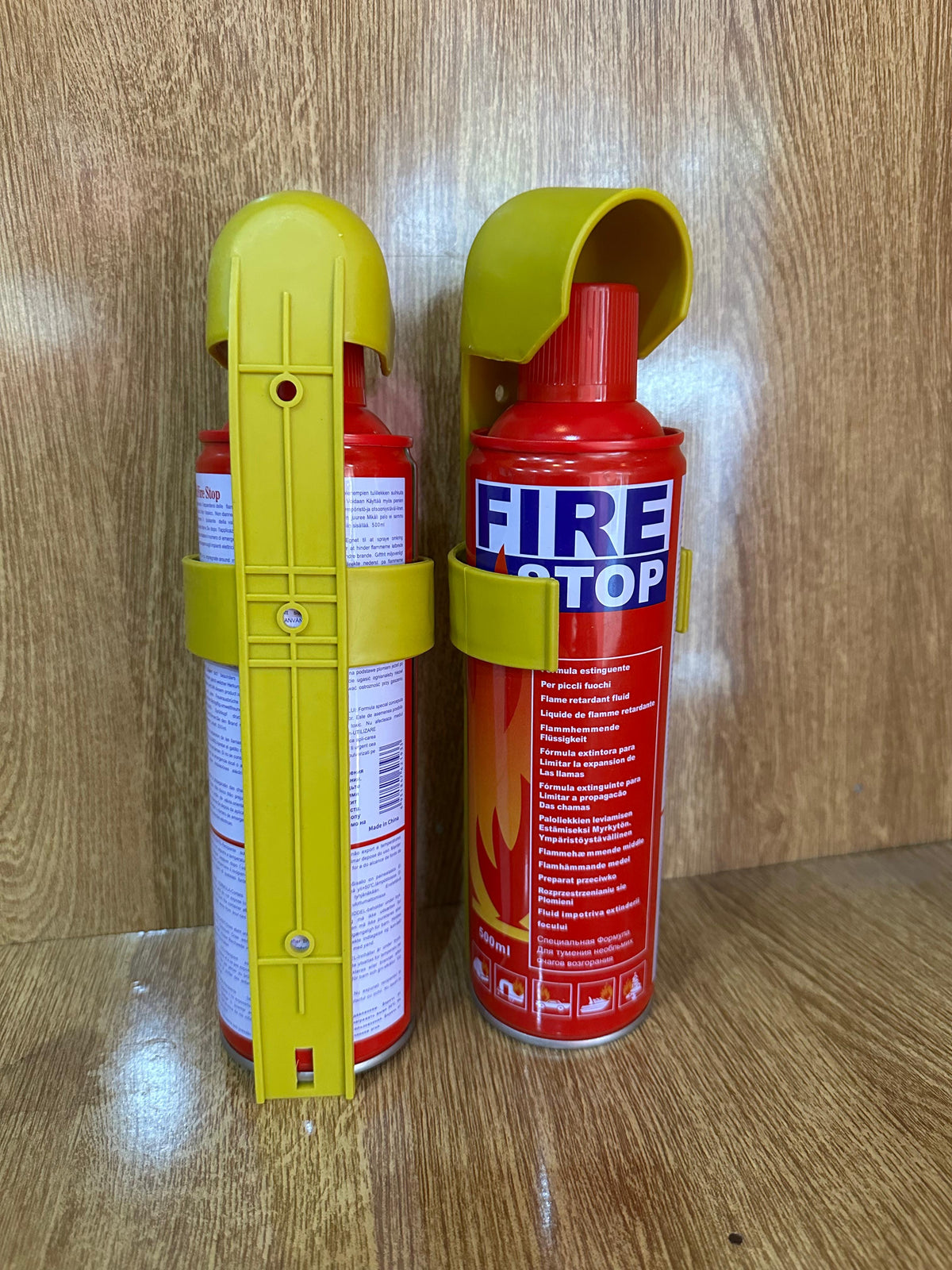 500ml Fire Stop Spray portable fire extinguisher secured in a bright yellow plastic mounting bracket
