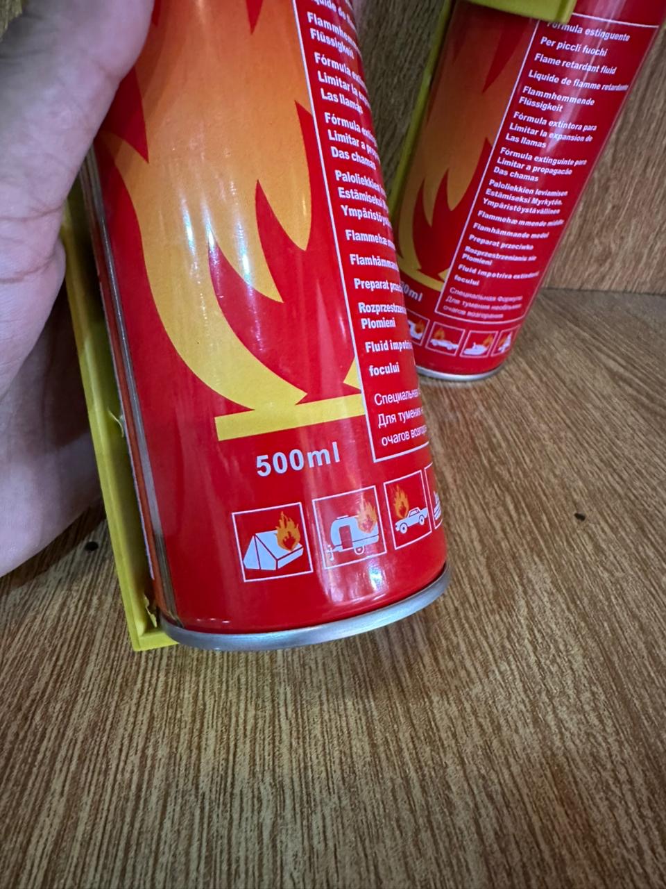 500ml Fire Stop Spray portable fire extinguisher secured in a bright yellow plastic mounting bracket