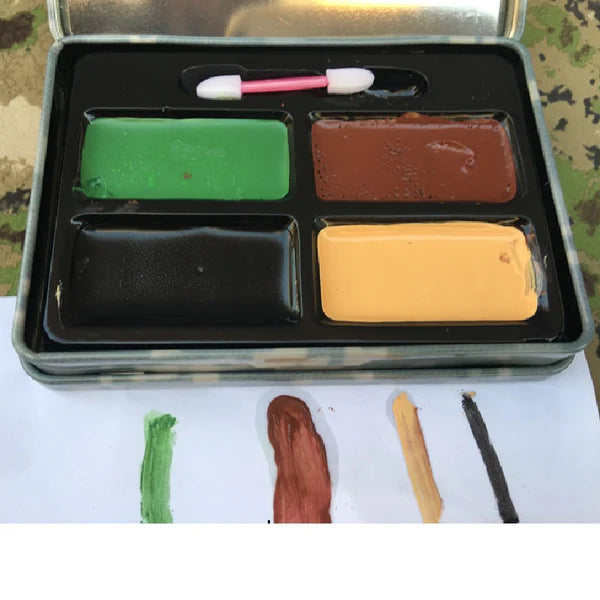 Set of watercolor paints in a metal case with paintbrushes on a camouflage 