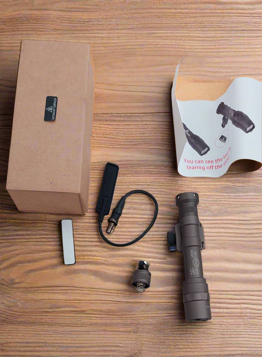 Gadgets and accessories on a wooden surface with a cardboard box.