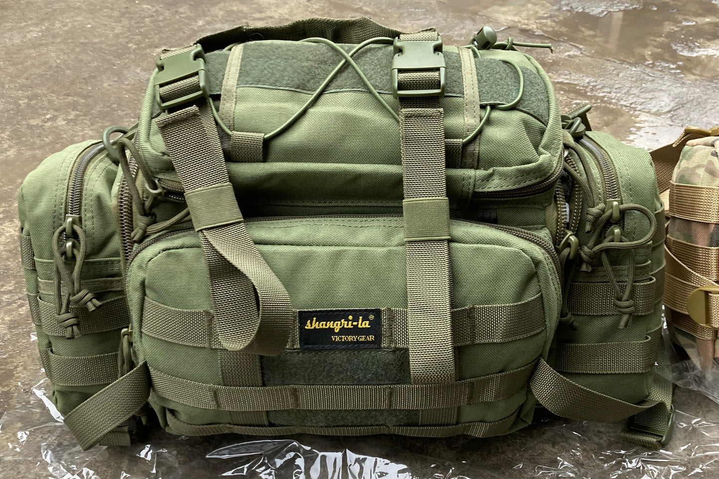 Green tactical bag on a reflective surface